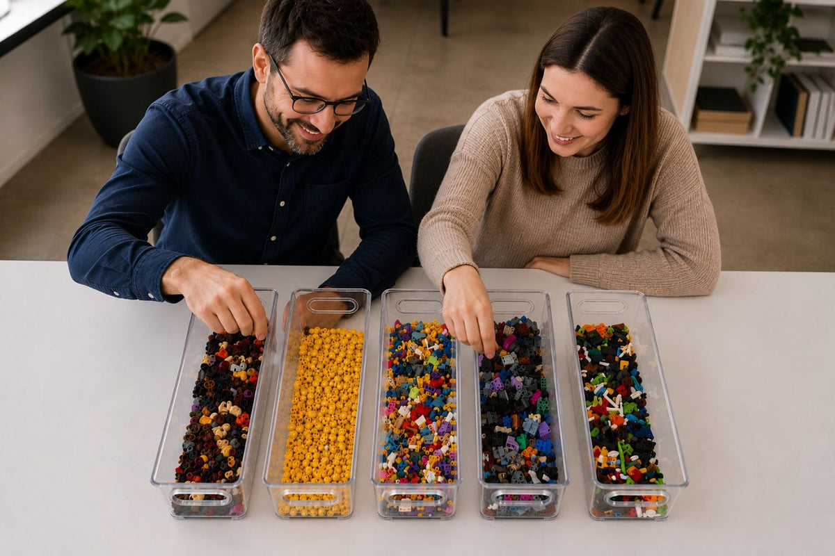 Two people sorting colorful LEGO minifigure pieces in clear containers on a table.